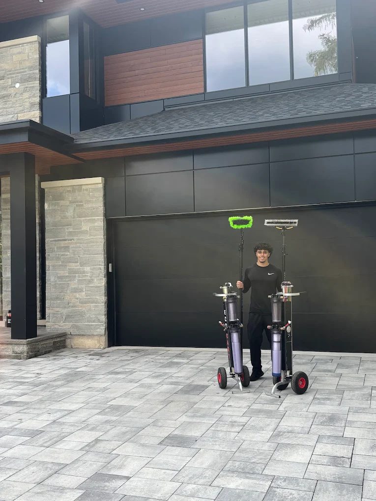 Farr Exteriors owner with water-fed pole window cleaning equipment in front of a home